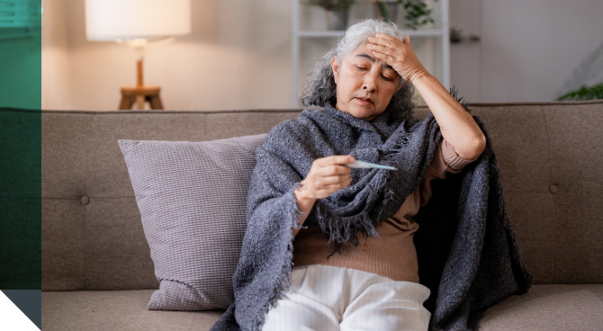 A woman checks her temperature after catching a respiratory virus.